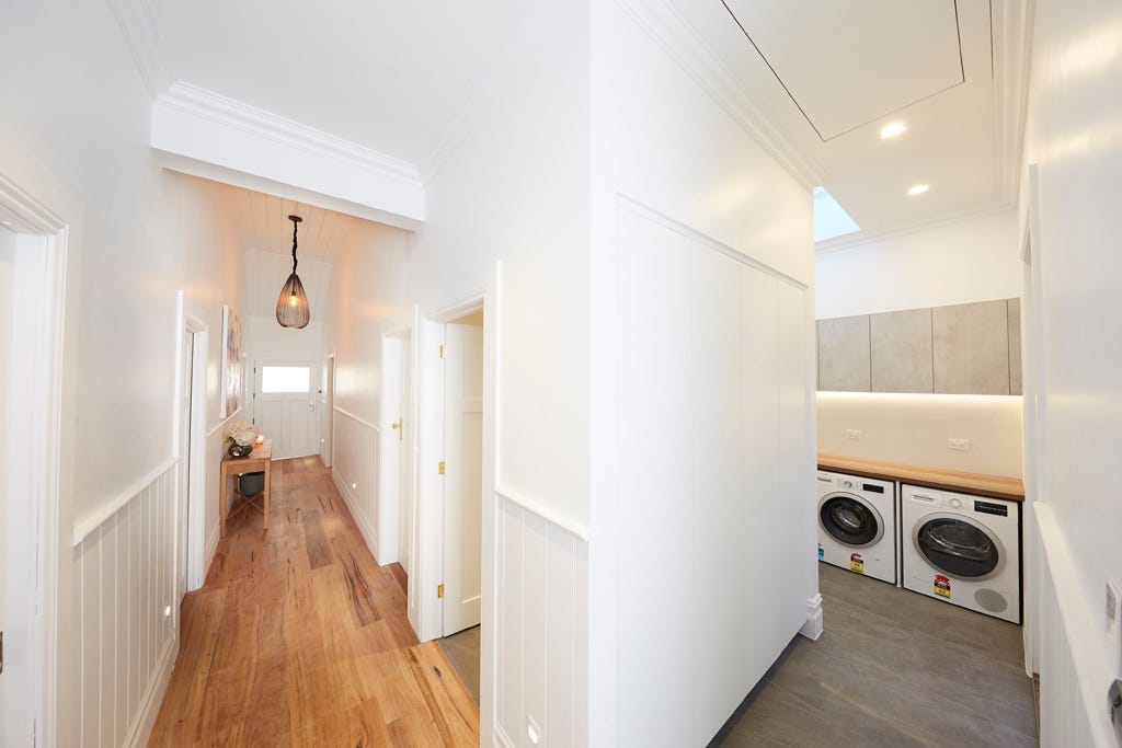 Sticks and Wombat used simple timber panelling, paired with a white colour palette, soft, beachwood details, and a stunning artwork to create their inviting hallway