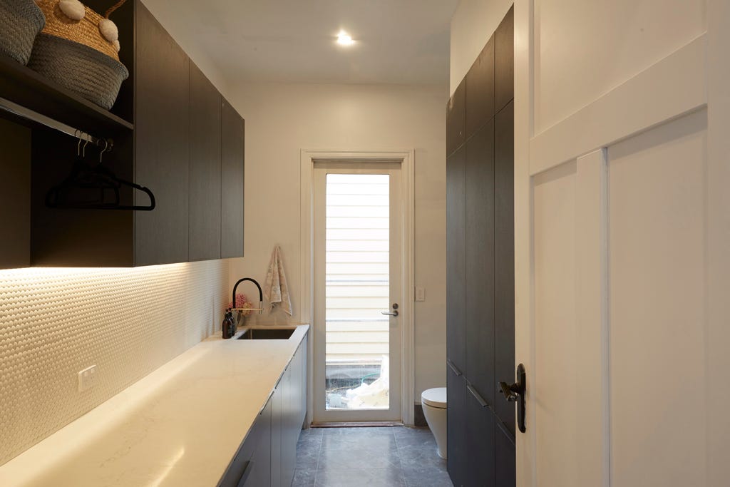 The white wall tiles worked well with the use of floor tiles, which in turn complemented the couple’s use of grey cabinetry and ceasarstone